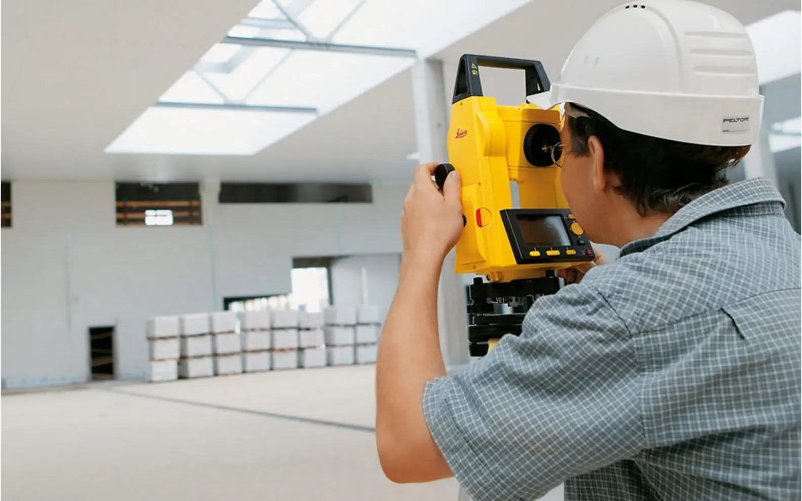 Building surveyor recording existing interior conditions with a total station