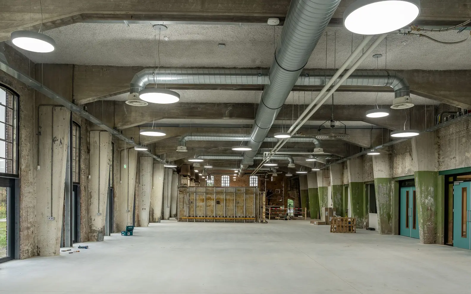 Exposed ventilation ductwork and building services installed across a modern industrial ceiling