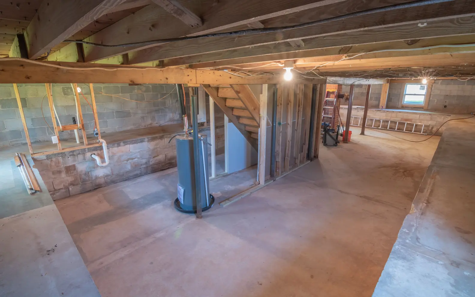 Exposed plumbing pipework installed below the structural framing of a building basement