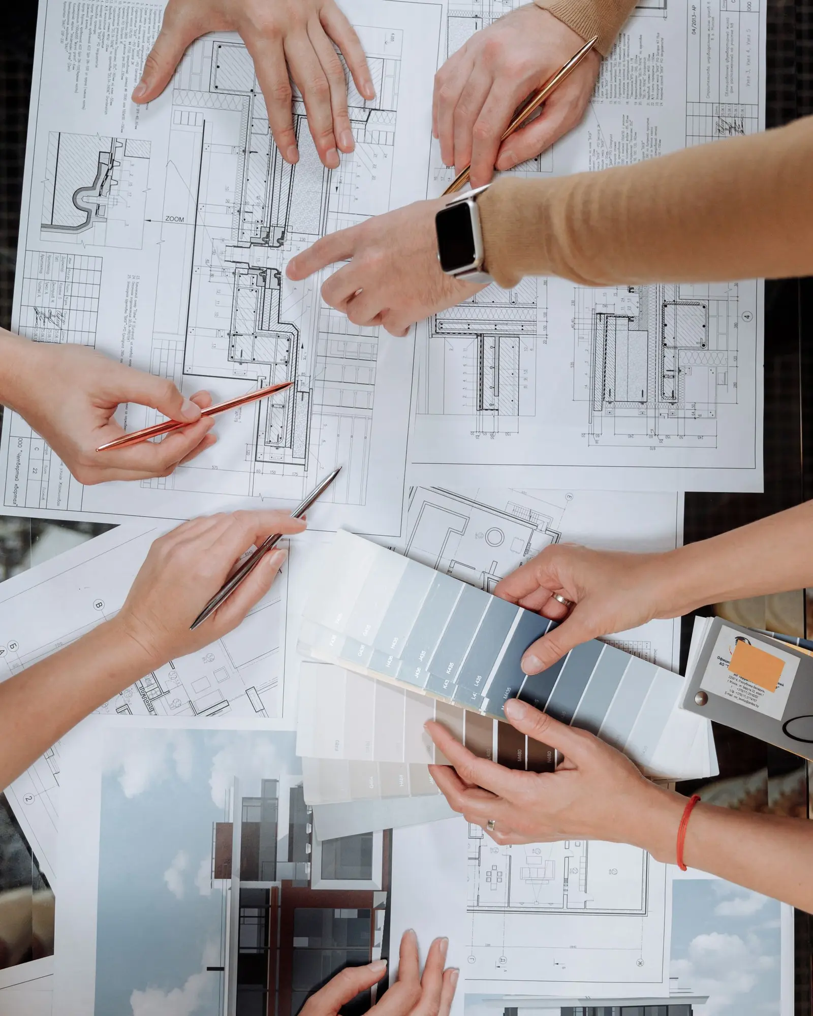 Project team reviewing architectural drawings, material samples and design options together