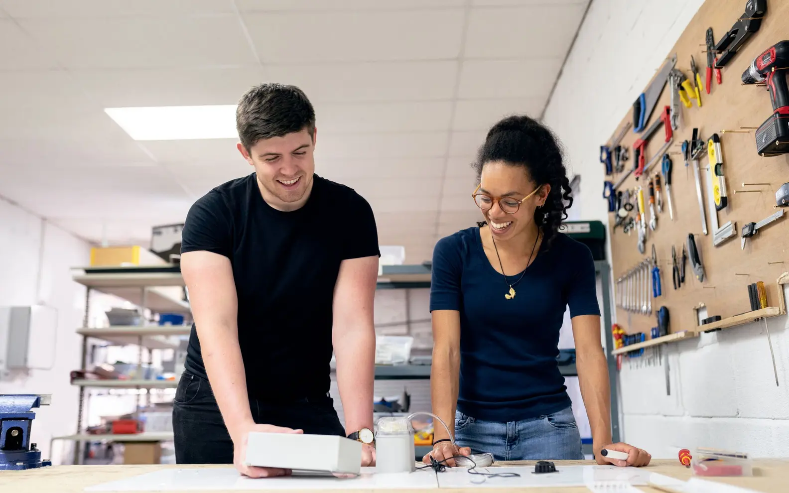 Two engineers collaborating on a physical prototype in a product development workshop