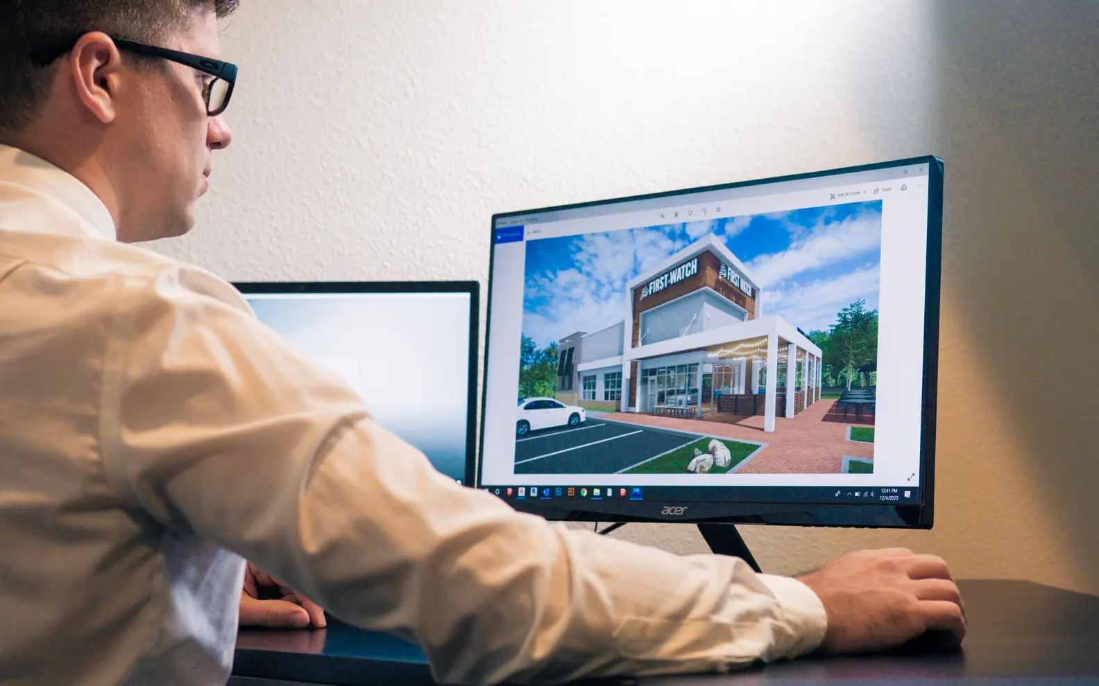 Design professional reviewing a three-dimensional building model on an office monitor
